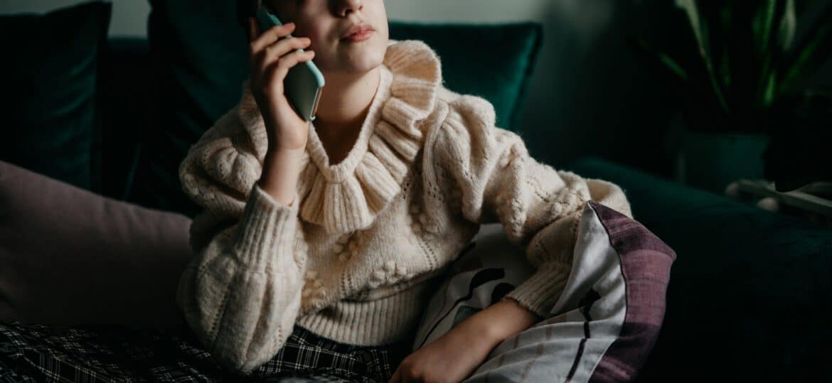 फोटो: एक किशोरी एक अनिच्छुक स्टॉक फोटो में एक फोन पर बोलती है। 